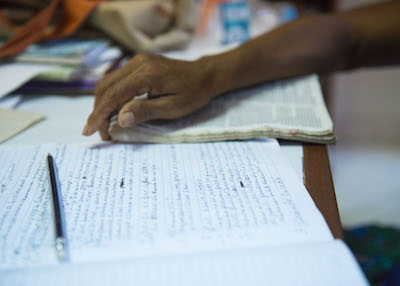 A woman works with notes and a Bible.